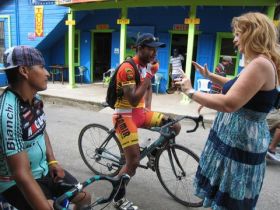 Macarena Rose in San Ignacio, Cayo district Belize talking to bicylist downtown – Best Places In The World To Retire – International Living